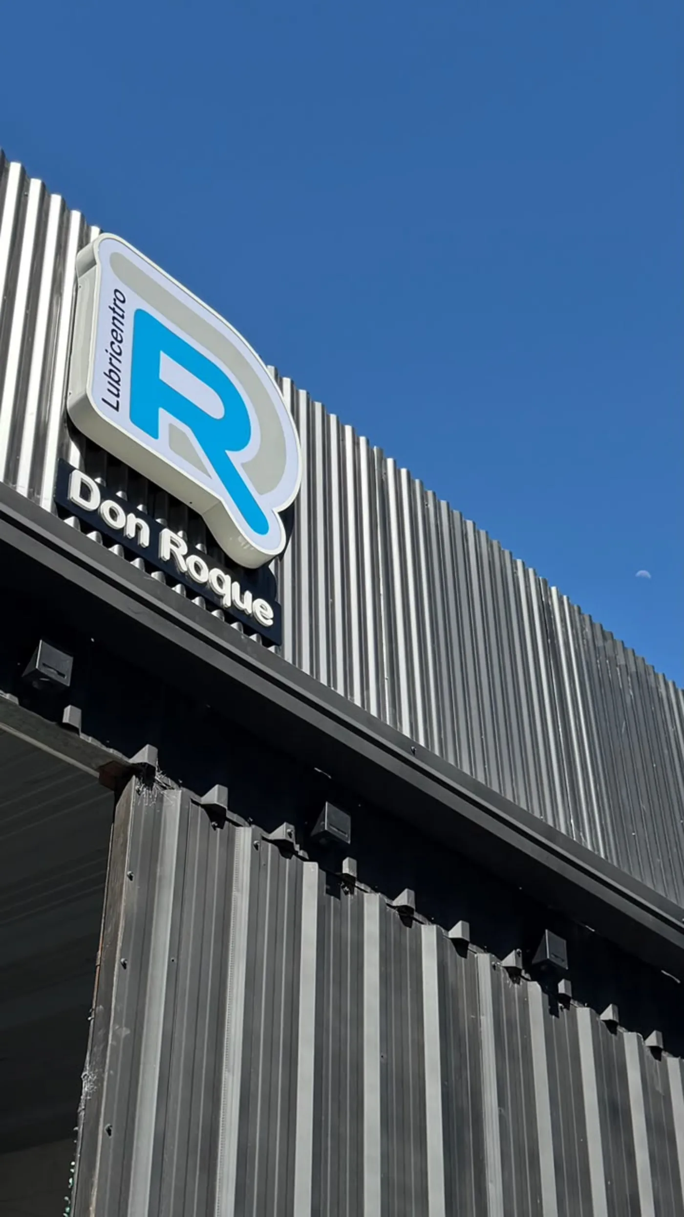 Cartel con el logo de Lubricentro Don Roque sobre Av. Bartolomé Mitre